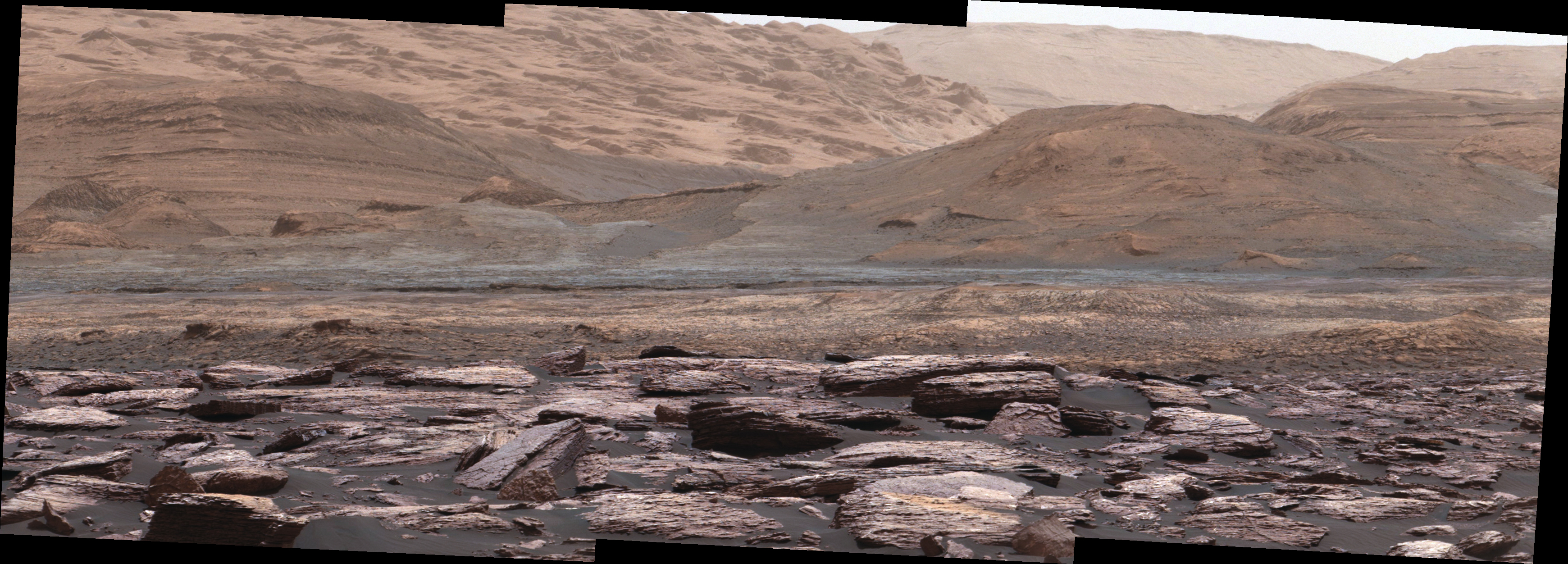 Pierwszy plan zdjęcia sfotografowanego przez Mastcam na łaziku Curiosity ukazuje fioletowe skały, które pojazd badał niedawno. Wzgórza w tle są następnym celem misji Curiosity. Różnorodność kolorów wskazuje na zróżnicowanie środowiska Marsa na różnych etapach jego historii.