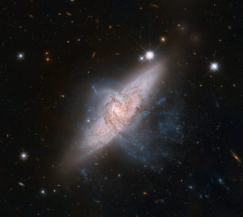 Zdjęcie głębokiego nieba. Dwie nachodzące na siebie galaktyki spiralne. W tle nieliczne dalsze obiekty.