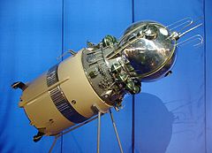 Stojący na dwóch rurkach metalowych statek Vostok 3K z podłączonych ostatnim stopniem rakiety