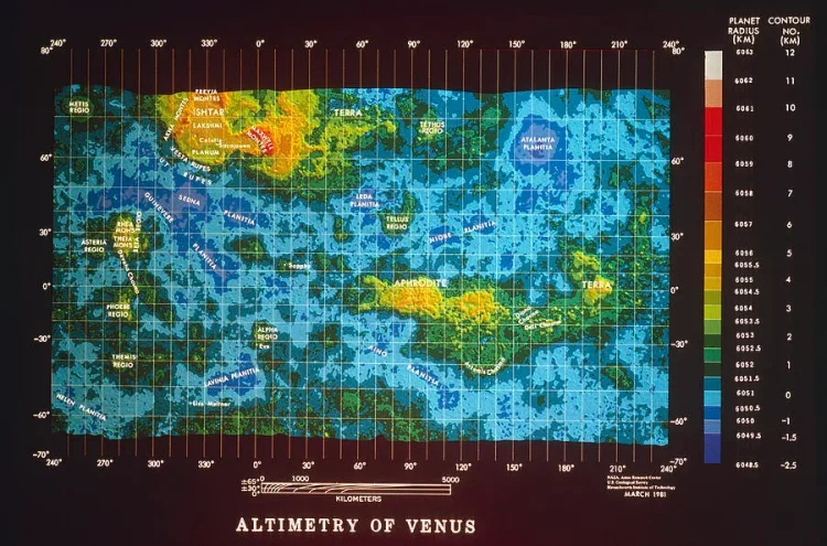 Mapa z wysokościami zaznaczonymi kolorami - najwyższe tereny są czerwone, niższe żółte i zielone, najniższe niebieskie. Podpis pod mapą "ALTIMETRY OF VENUS"