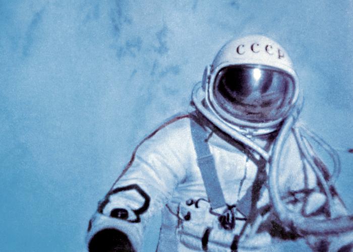 Kosmonauta w skafandrze unoszący się na tle Ziemi, obwiązany rurką. Jest widoczny tylko od pasa w górę.