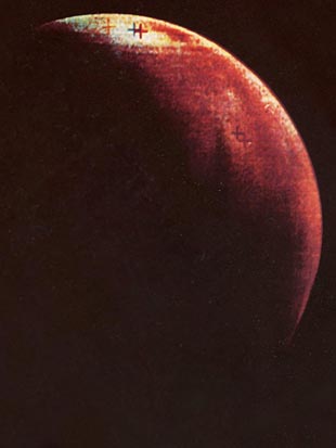 Słabej jakości zdjęcie fragmentu czerwonej planety na czarnym tle