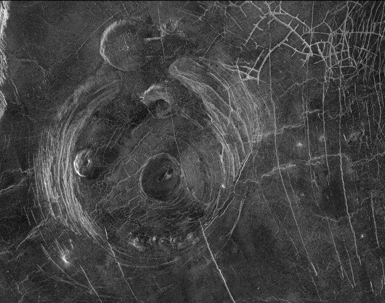 Obrazek w czerni i bieli. Struktura powierzchni planety przypominająca okrągłą pajęczynę.