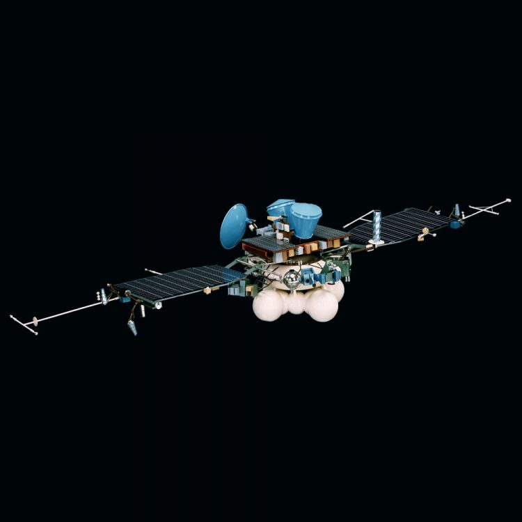Na czarnym tle sonda złożona z centralnej biało-niebieskiej części i dwóch rozłożonych paneli słonecznych po bokach