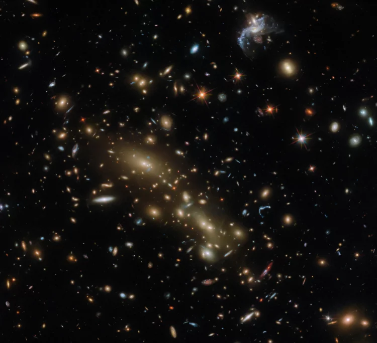 Na obrazie liczne galaktyki zgrupowane w dwie gromady na tle głębokiego kosmosu