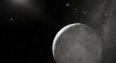 W prawym dolnym rogu szara planeta z licznymi kraterami, ponad nią niewielki księżyc. Po lewej stronie dalekie Słońce. W tle ciemne niebo i gwiazdy.