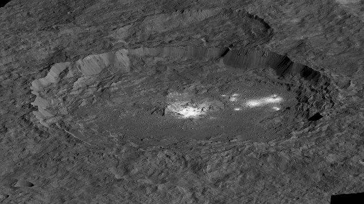 Zdjęcie czarno-białe. Krater z płaskim dnem z dwoma białymi plamami w jego centrum