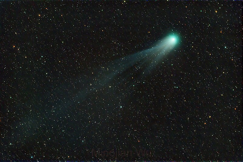 Błękitna kometa z warkoczem na tle gwiazd.