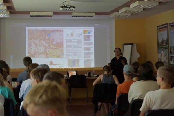 Uczesnicy wpatrują się w tablicę.