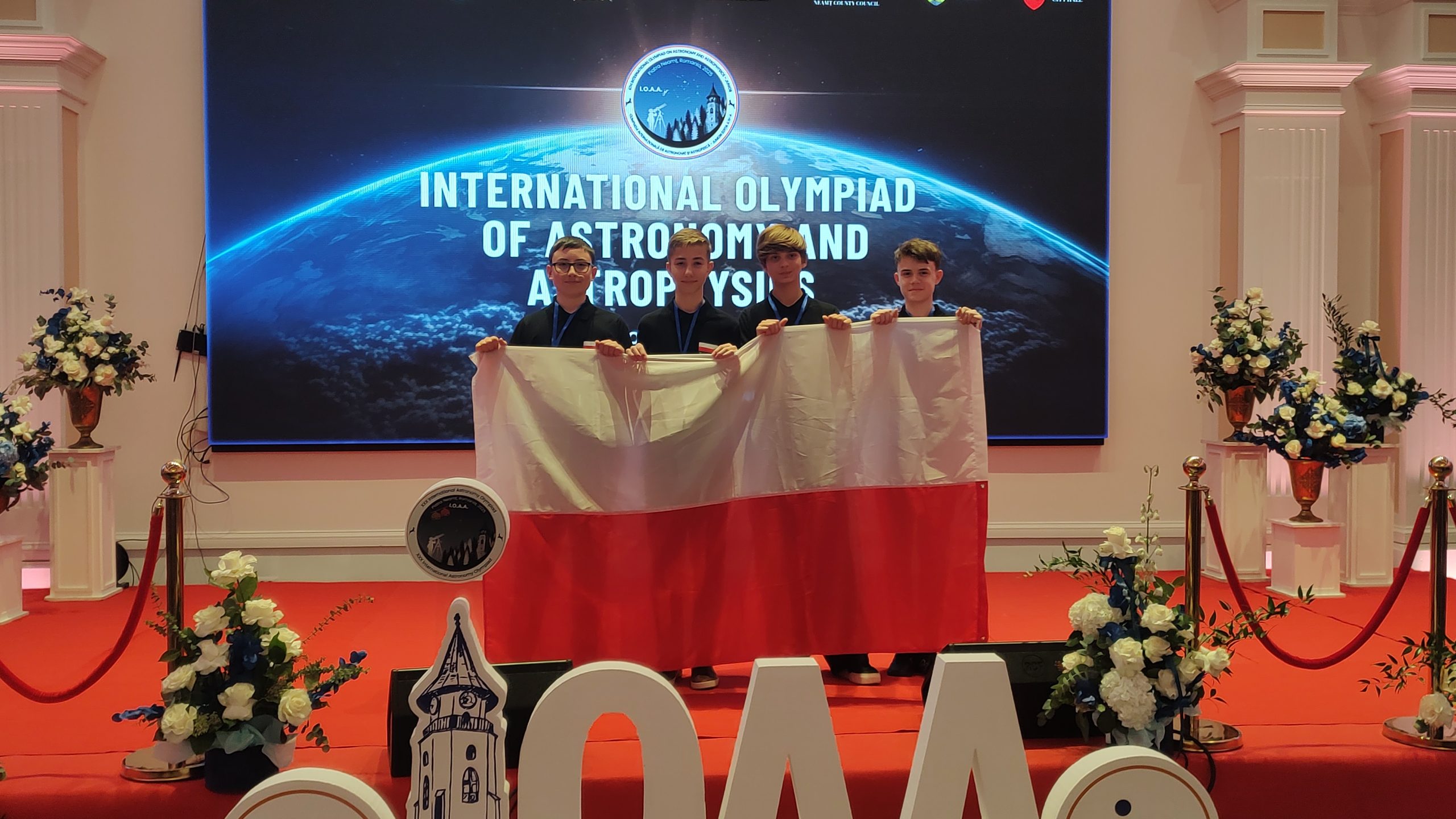 CZworo chłopaków trzymających polską flagę.