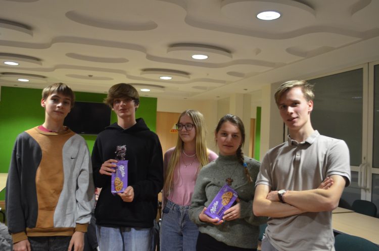 Pięć osób ustawionych do zdjęcia. Dwie z nich trzymają paczki ciasteczek.